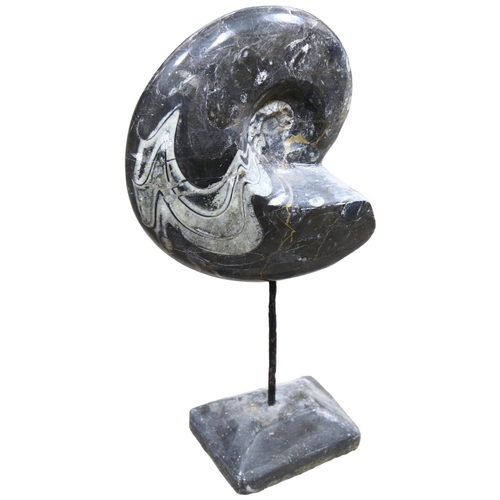 328 - A prehistoric fossilised goniatite on metal stand, height 50cm