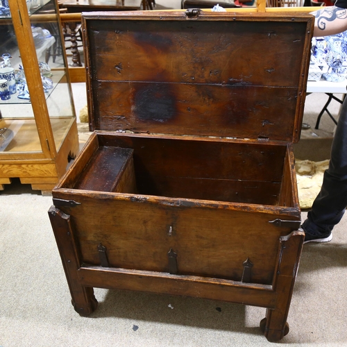 331 - An Afghan metal-bound hardwood coffer on wheels, with iron strapwork hinges, length 87cm