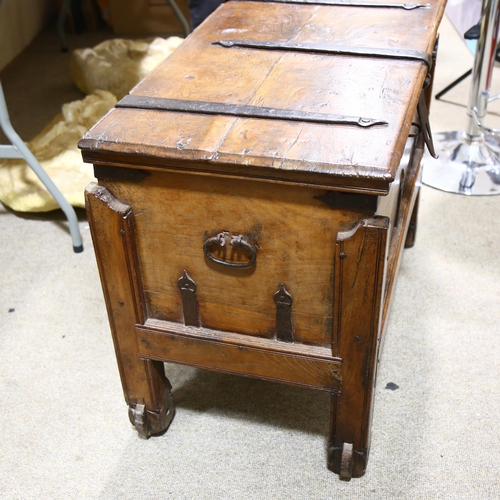 331 - An Afghan metal-bound hardwood coffer on wheels, with iron strapwork hinges, length 87cm