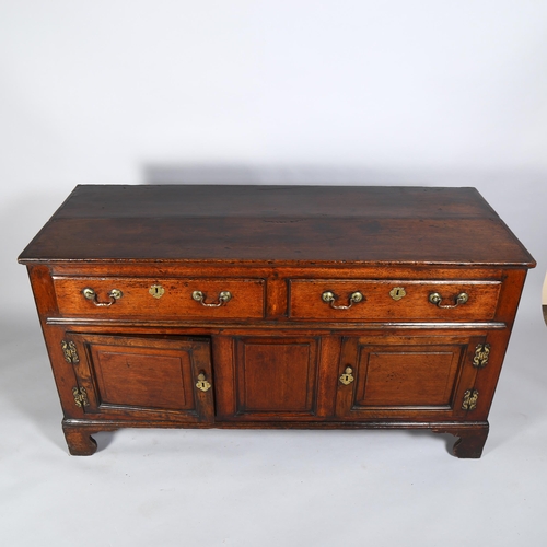 7 - An 18th century oak dresser base, with 2 frieze drawers, 2 fielded panelled cupboards under and blan... 