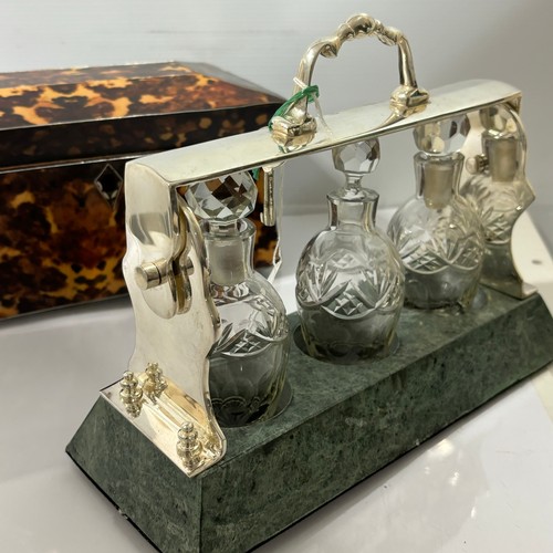 378 - A cut-glass and silver plate 3-bottle liqueur tantalus, on green marble base, length 26cm, and a rep... 