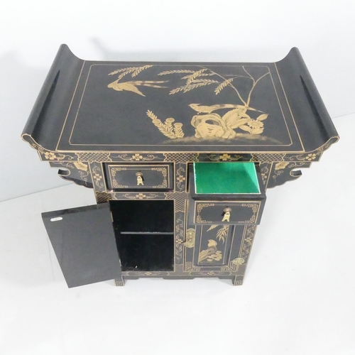 2005 - A contemporary Oriental black laquered altar cabinet, with gilt painted decoration, two drawers and ... 