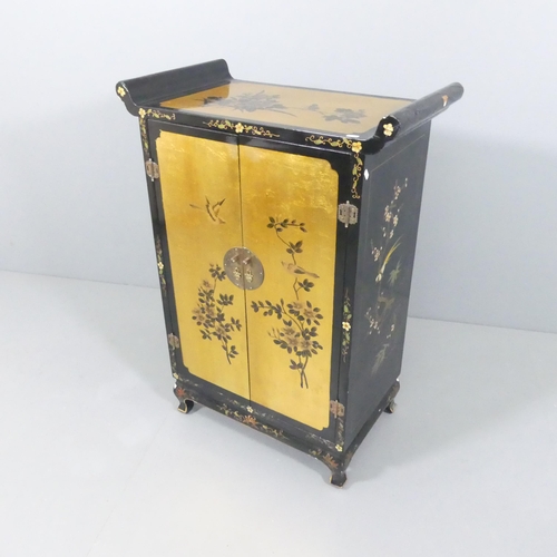 2006 - A contemporary Oriental black lacquered two door cabinet, with gilt painted and gold leaf decoration... 