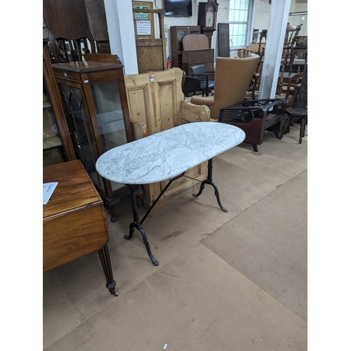 2722 - A oval marble topped table on cast iron base. 119x72x60cm