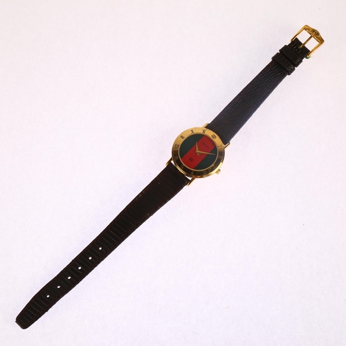 1046 - GUCCI - a lady's gold plated 3000L quartz wristwatch, circa 1992, green and red strip dial, with lan... 