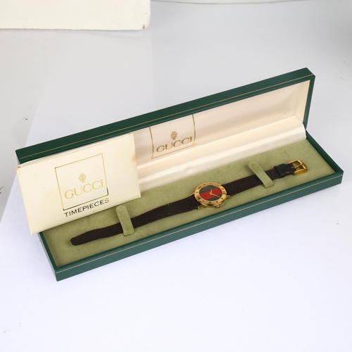 1046 - GUCCI - a lady's gold plated 3000L quartz wristwatch, circa 1992, green and red strip dial, with lan... 