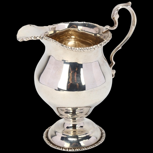 1738 - A George V silver helmet pedestal cream jug, B S Barnsley & Co, Birmingham 1912, 11cm, 5.1oz