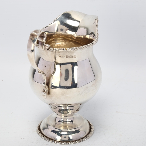 1738 - A George V silver helmet pedestal cream jug, B S Barnsley & Co, Birmingham 1912, 11cm, 5.1oz