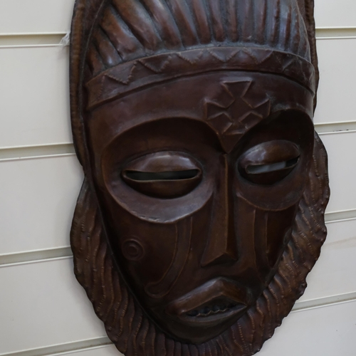 126 - A large pressed copper African mask, L52cm