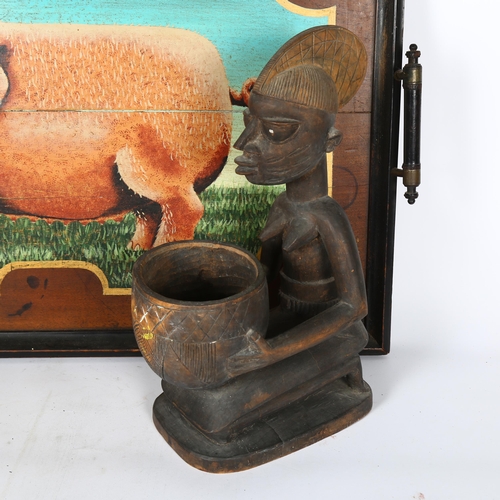 202 - A carved stained wood African woman holding a bowl, H36cm, and a wooden tea tray with painted design... 