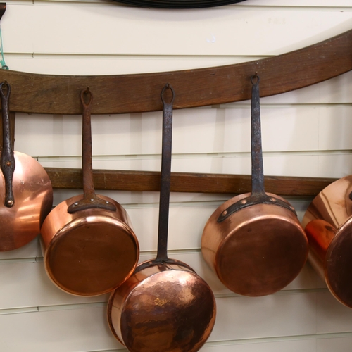 309 - A group of 5 Antique French copper cooking pots and pans, with cast-iron handles, on associated wood... 