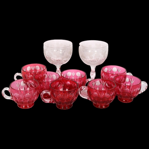 353 - A collection of cranberry overlay cups, and a pair of engraved glasses with cut stems