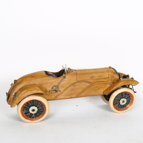 384 - Clive Fredriksson, stylised carved and polished wood study of a Vintage motorcar, L42cm