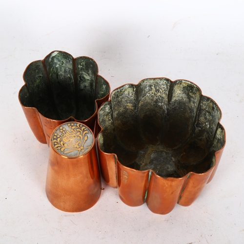 495 - 2 Antique copper jelly moulds, H6cm, and a copper tot with coin set base (3)