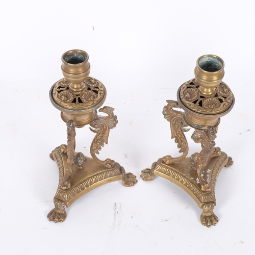56 - A pair of 19th century Empire style brass candlesticks, phoenix supports, the sconces loose revealin... 