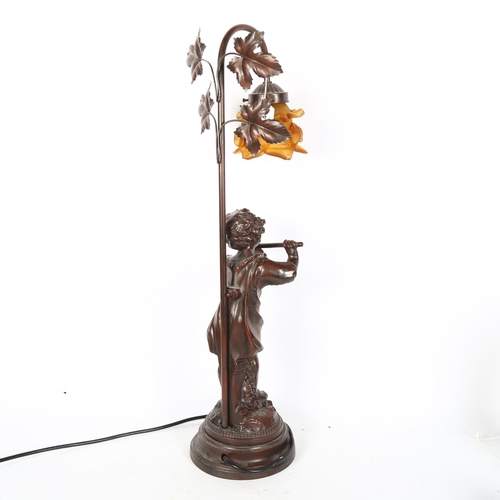 594 - A composition table lamp supported by cherub musician, with amber glass shade, 65cm