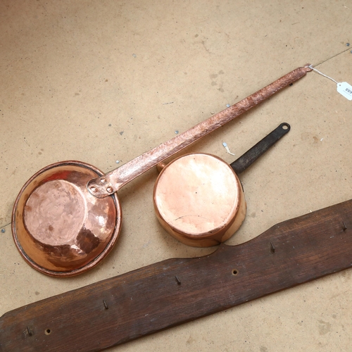 688 - A long-handled copper pan, 77cm, a copper milk pan, and coat hooks