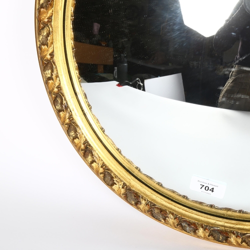 704 - A gilt and gesso convex wall mirror, diameter 46cm