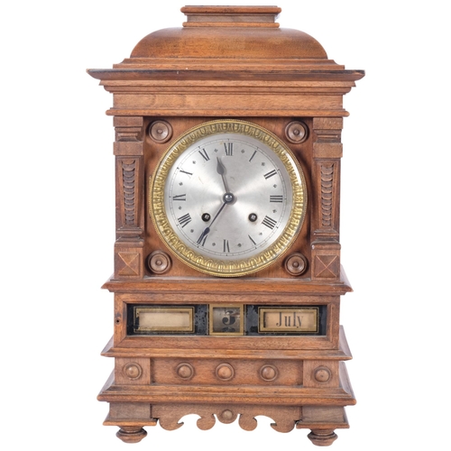 74 - An unusual walnut-cased calendar mantel clock, with silvered dial and 8-day gong striking movement, ... 