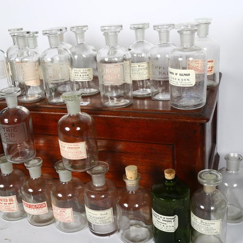 779 - Antique oak box containing assorted glass chemist bottles with stoppers, with labels from various ph... 