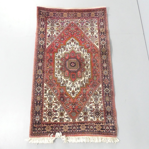 2117 - A red and cream-ground Persian rug. 112x76cm.