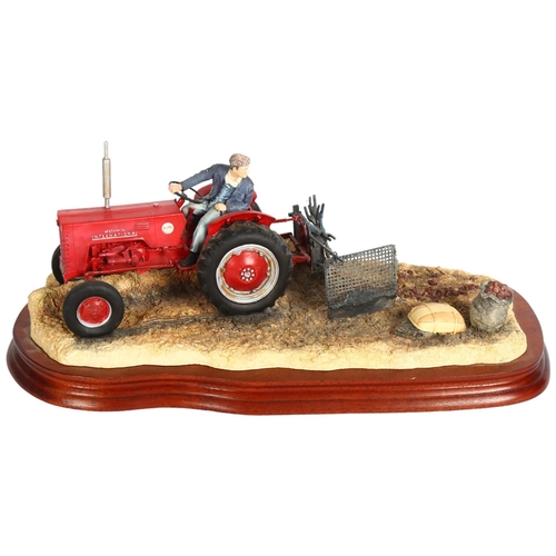 921 - A Border Fine Arts sculpture of a tractor driver, on wooden plinth, 