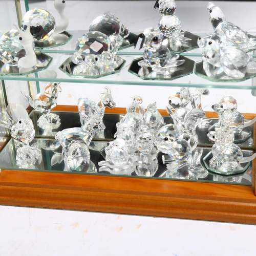 1053 - A collection of miniature Swarovski glass animals (19), in a table-top display cabinet, cabinet heig... 