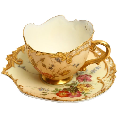 A Royal Worcester Blush Ivory Empress tea cup and saucer,  decorated with sprays of flowers, with pierced edge, gilded highlights with puce mark and shape no. 1471
