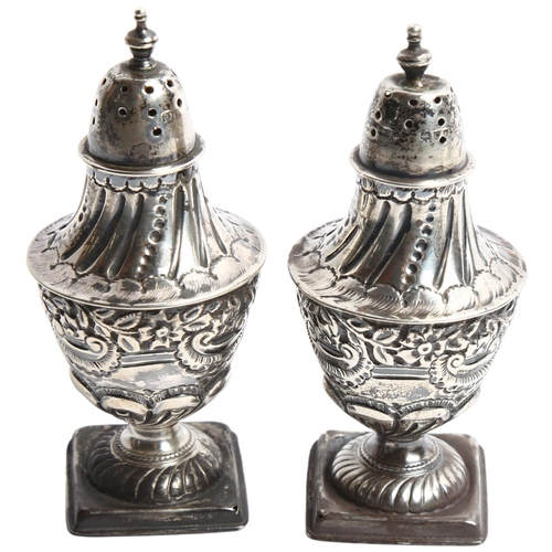 1287 - A pair of embossed silver pepperettes on square bases, hallmarks for London 1895