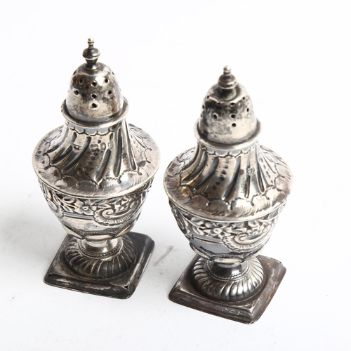 1287 - A pair of embossed silver pepperettes on square bases, hallmarks for London 1895