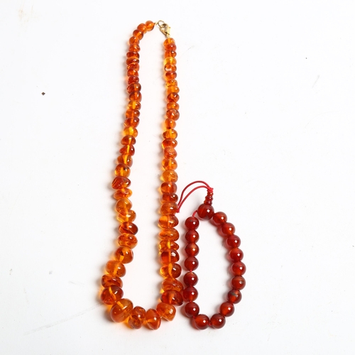 1296 - A polished amber bead necklace, and a carnelian bracelet