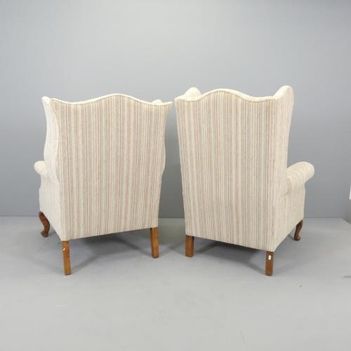 2687 - An early 20th century his and hers pair of walnut and upholstered wingback fireside armchairs.