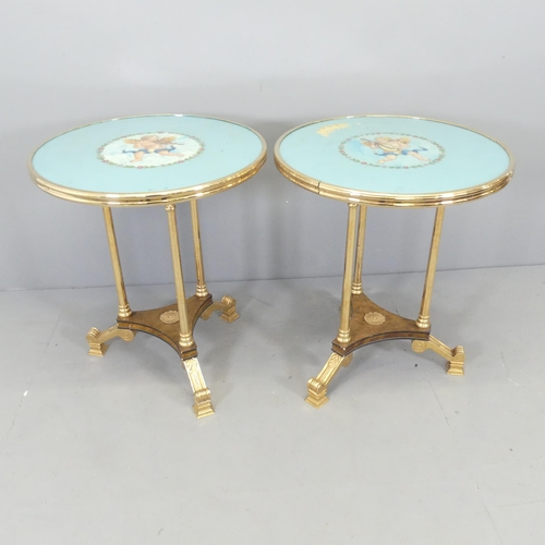 2631 - A pair of Hollywood Regency style brass effect two-tier side tables, with painted cherub design to t... 