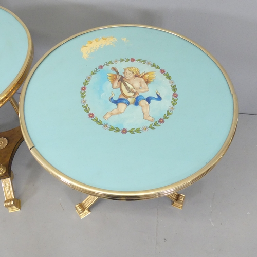 2631 - A pair of Hollywood Regency style brass effect two-tier side tables, with painted cherub design to t... 