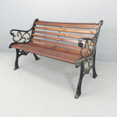 2641 - A stained pine slatted garden bench with painted cast iron ends. 125x77x68cm.