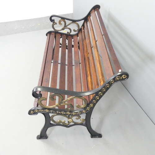 2641 - A stained pine slatted garden bench with painted cast iron ends. 125x77x68cm.