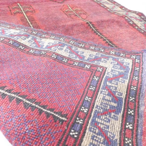 2127 - A red-ground Baluchi rug. 135x90cm