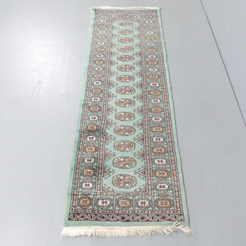 2128 - A green-ground Persian runner. 196x65cm.