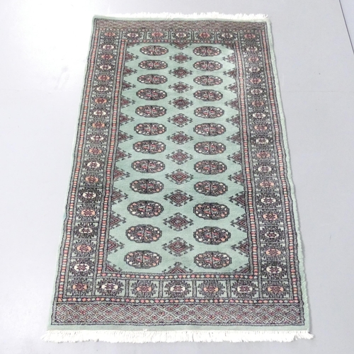 2129 - A green-ground Persian rug. 149x93cm.