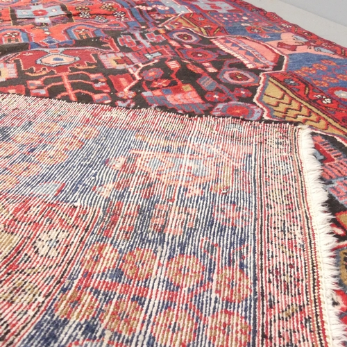 2132 - A red-ground Persian Nahavand carpet. 293x145cm.