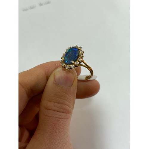 1111 - A modern 18ct gold black opal and diamond oval cluster ring, set with oval cabochon opal and modern ... 