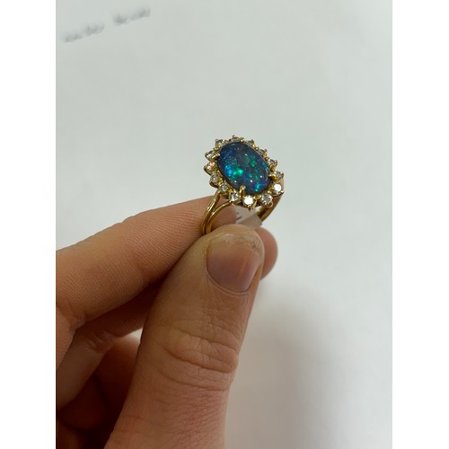 1111 - A modern 18ct gold black opal and diamond oval cluster ring, set with oval cabochon opal and modern ... 