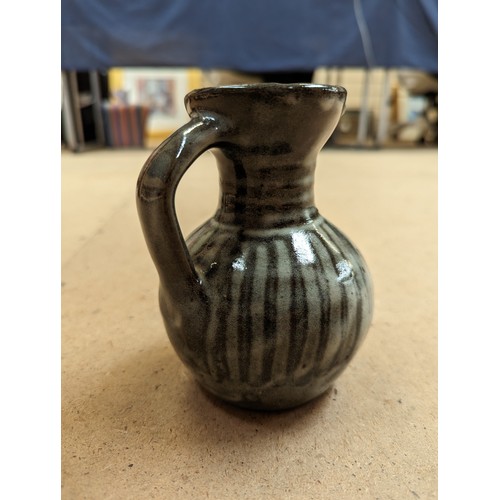 714 - 3 pieces of Studio pottery, Seth Cardew cup and saucer and a large Abuja pottery tankard, both with ... 