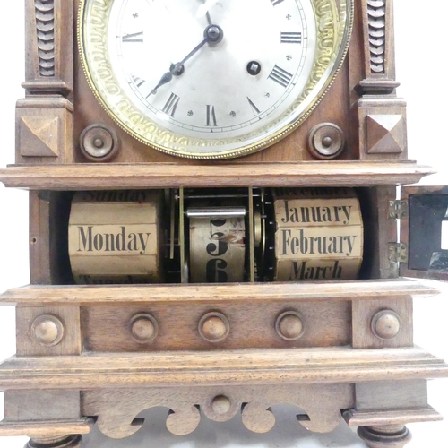 74 - An unusual walnut-cased calendar mantel clock, with silvered dial and 8-day gong striking movement, ... 