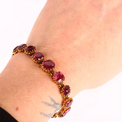 1111 - An Edwardian graduated garnet line bracelet, unmarked gold settings, claw set with oval and cushion-... 