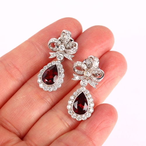 1173 - A pair of South African 14ct white gold garnet and diamond drop earrings, by Charles Greig, with mod... 