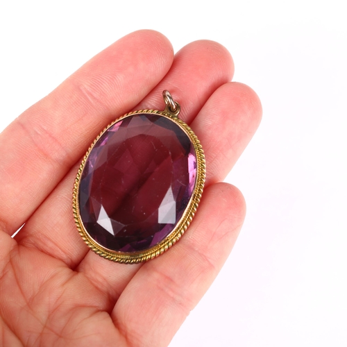 1181 - A large amethyst pendant, rub-over set with oval mixed-cut amethyst within unmarked yellow metal rop... 