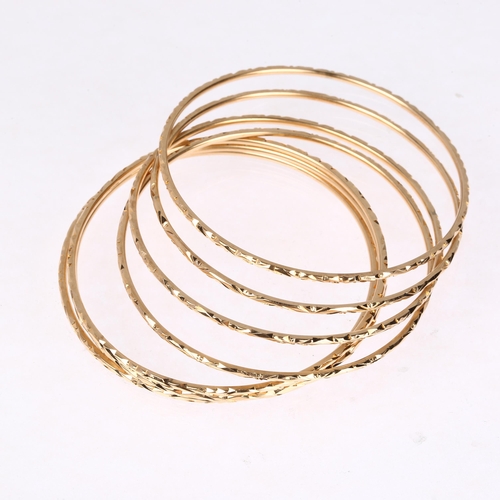 1216 - A set of 7 x 14ct gold slave bangles with engraved decoration, each band width 1.9mm, internal circu... 