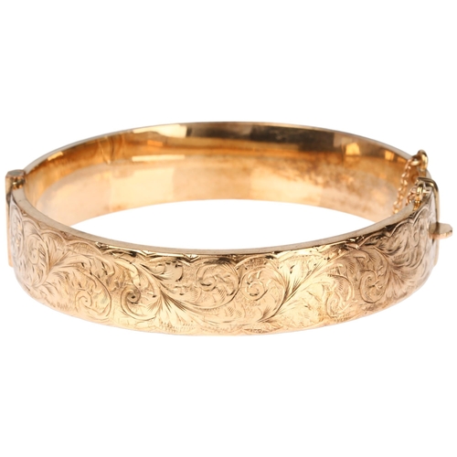 1217 - A mid-20th century 9ct gold hinged bangle, maker S&P, Birmingham 1963, with engraved foliate decorat... 