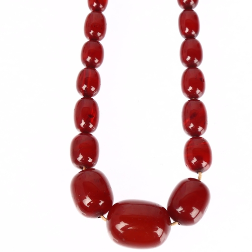 1231 - A single-strand graduated cherry amber barrel bead necklace, beads ranging from 34.4-12mm, necklace ... 